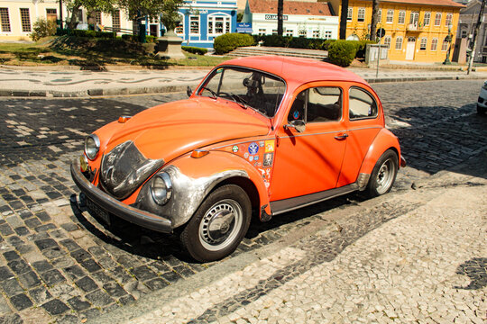 Um Volkswagen Typ 1, de cor laranja decorado com v&aacute;rios adesivos, conhecido no Brasil como Fusca ou Carocha em Portugal, em curitiba paran&aacute;, sul do brasil.