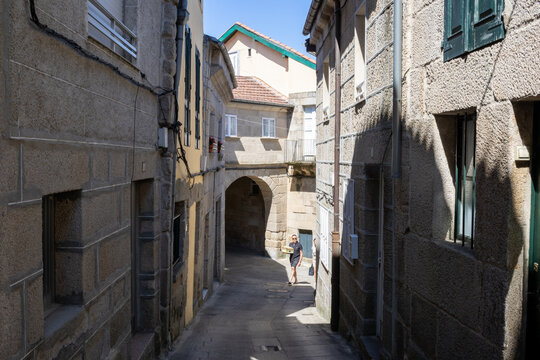 Narrow historic cobblestone streets and traditional granite stone houses in the old town of Allariz, Ourense, Galicia, Spain. Ancient medieval architecture under a sunny summer sky.