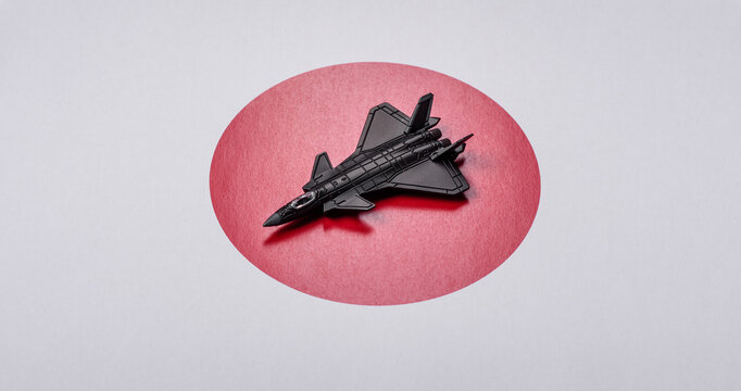 A fighter jet against the Japanese flag as a conceptual background representing defense