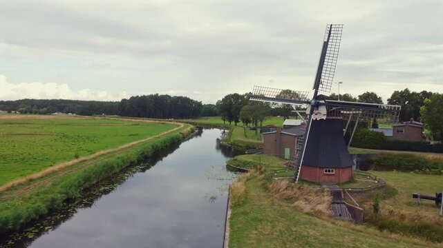 Aerial view of the historic drainage windmill De Boezemvriend in the town of De Groeve, revealing the Dutch countryside and canal