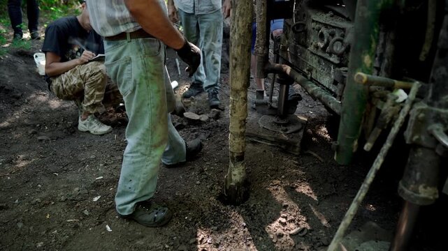 Engineers and drilling specialists operate the drilling equipment while collecting subsurface soil samples for geotechnical analysis, foundation design, and pre-construction site assessment in Ukraine