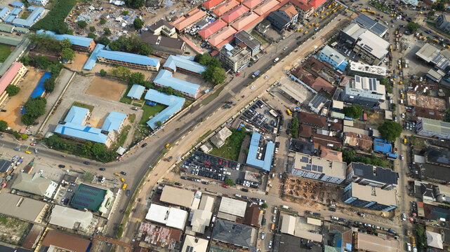 Aerial view of the urban landscape of Ibadan, featuring dense residential and commercial buildings, a major road intersection, and school facilities in Ibadan, Oyo, Nigeria.