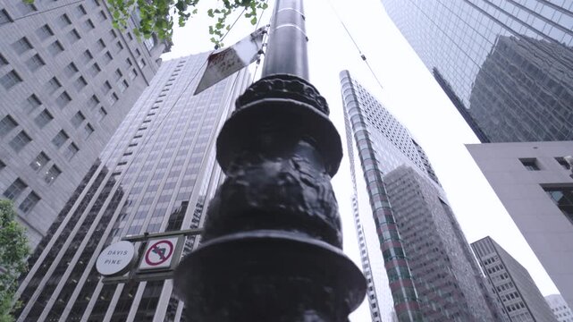 Street Lamp and Street Signs Near tall San Francisco Skyscrapers - low, steady cam shot