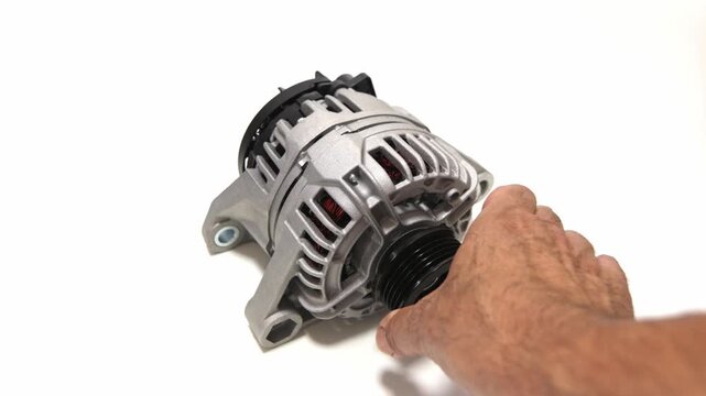 High quality studio shot of a hand rotating a car alternator pulley over a clean white background. Perfect for commercial auto repair ads, educational mechanical videos, and e commerce catalogs.
