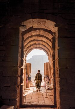 Tourist at the entrance to one of the royal tombs, rock carved mausoleum, Nabataean city of Petra, near Wadi Musa, Jordan
