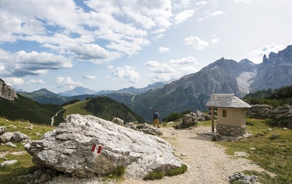 Walker near a chapel, circular trail around the Sella Group, Gardena Pass, Passo Gardena, nature park Park Puez-Geisler, Dolomites, Selva di Val Gardena, South Tyrol, Trentino-Alto Adige, Italy