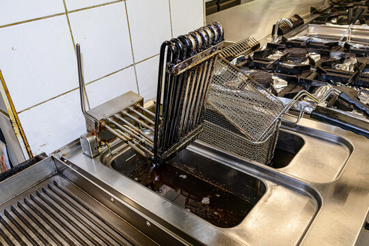 Commercial deep fryer with stacked frying baskets in professional restaurant kitchen