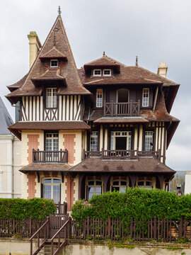 Vista de la fachada de casas lujosas con tejados puntiagudos y entramado de madera en la fachada en la Playa de Trouville-sur-Mer, viajando por la Normand&iacute;a francesa en verano 2022
