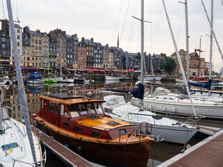 Vista del pintoresco puerto de Honfleur, donde se ven edificios al fondo y barcos recreativos en primer plano, viajando en verano de 2022 por la Normandía Francesa © acaballero67