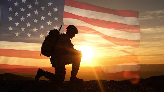 Silhouette of kneeling American soldier against sunset sky with waving United States flag