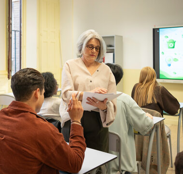 Teacher talking with students about sustainability in a university classroom