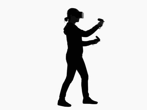 Silhouette of a woman wearing a virtual reality headset and holding controllers, symbolizing immersive technology and digital entertainment.