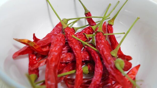 Close up macro view of shriveled red hot chili peppers with slender green stems