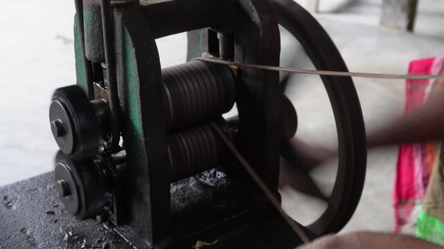 Jeweler drawing gold with rolling mill machine