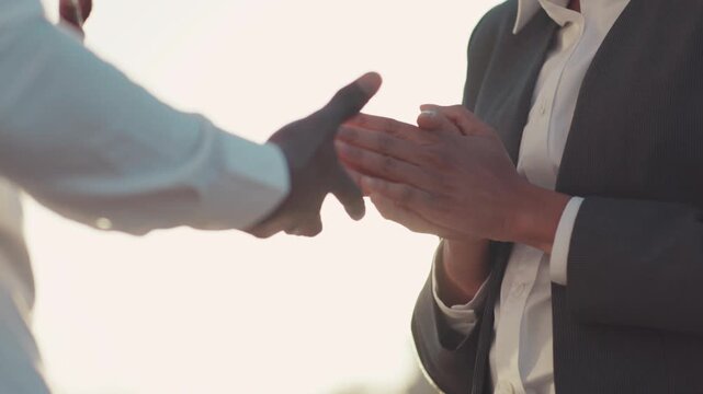 Man and woman in a formal wear actively gesticulate while having a conversation, then they shake their hands in agreement. Business meeting, contract, luxury. Career goals.