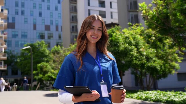 Young female doctor walking outside modern hospital
