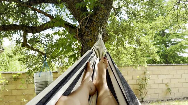 Relaxing in a hammock under a tree on a sunny day