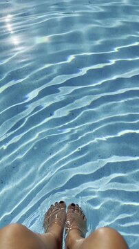 Relaxing summer dip with feet in clear water