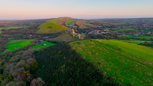 Aerial sunset view of Corfe Castle, a village and civil parish in the English county of Dorset, UK