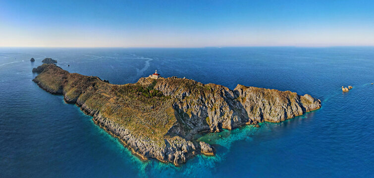 Aerial view of Palagruza island featuring its historic lighthouse, rugged rocky terrain, and clear turquoise waters of the Adriatic Sea in Palagruza, Split-Dalmatia County, Croatia.