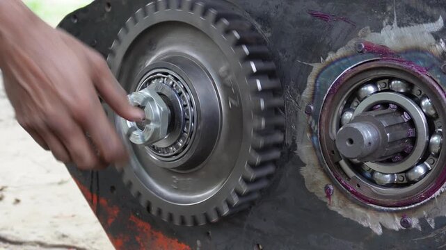 Technician assembling heavy machine metal gear