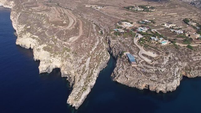 Ix-xini, Gozo, Malta - serene aerial view of rocky coastline with rugged terrain and blue water in natural landscape. High quality 4k footage