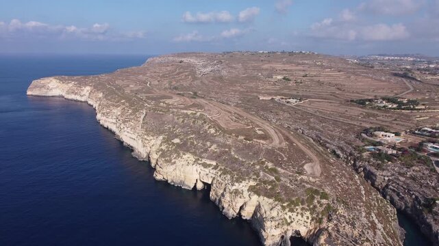 Ix-xini, Gozo, Malta - serene aerial view of rocky coastline with rugged terrain and blue water in natural landscape. High quality 4k footage