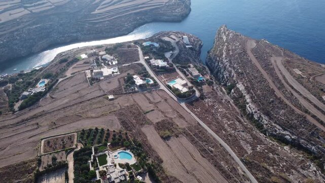 Ix-xini, Gozo, Malta - serene aerial view of rocky coastline with rugged terrain and blue water in natural landscape. High quality 4k footage