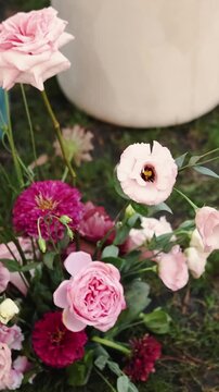 Vertical video. Floral wedding arrangement with pink blooms decorating the outdoor ceremony venue.