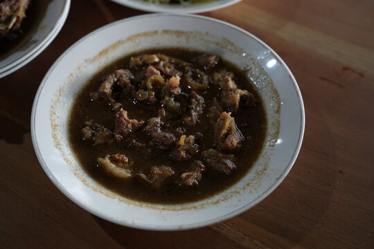 Authentic Indonesian Rawon, a traditional East Java black beef soup with rich keluak broth, served in a white bowl. Classic comfort food perfect for culinary and travel photography.