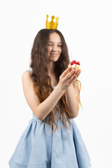 Young smiling woman wearing crown and holding cupcake in a professional photo...