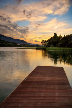 Scenic landscape of Sobron reservoir featuring mountain reflections in the calm water with green forests and a dramatic sky in northern Spain