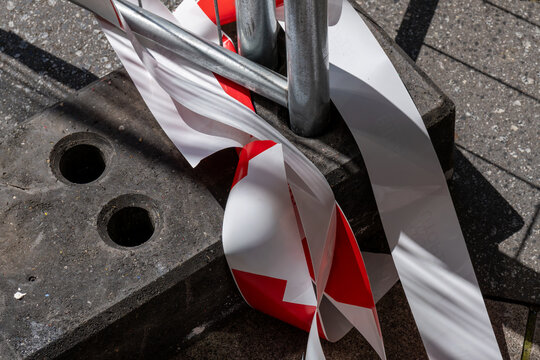 Red and white striped construction site barrier with warning elements. Urban roadwork and safety concept.