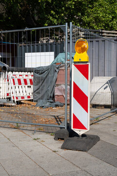 Red and white striped construction site barrier with warning elements. Urban roadwork and safety concept.