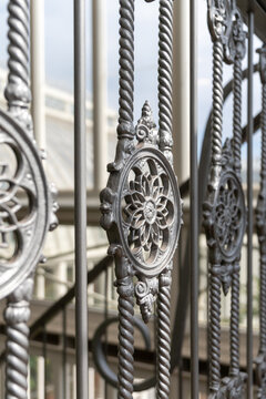 Ornate cast iron structural elements and metal railing of a historic industrial building.