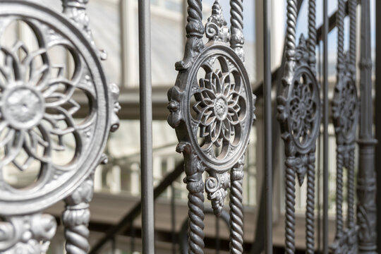 Ornate cast iron structural elements and metal railing of a historic industrial building.