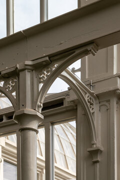 Ornate cast iron structural elements and metal railing of a historic industrial building.