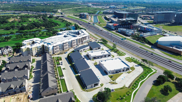 Office parks sit near expansive Las Colinas business hub within North Irving, Texas. Uniform roofing patterns harmonize with manicured landscaping throughout quiet corporate landscape of region