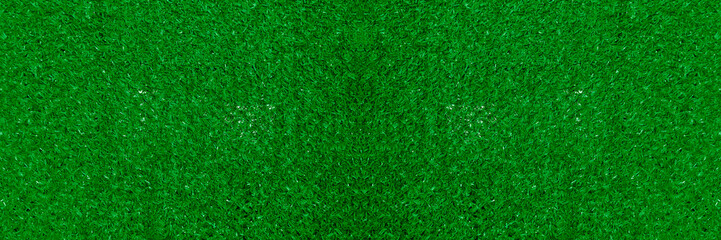Fototapeta premium artificial plastic synthetic green grass fence close-up texture pattern background backdrop Artificial grass texture woven through a chain link fence creating a vibrant green background for design