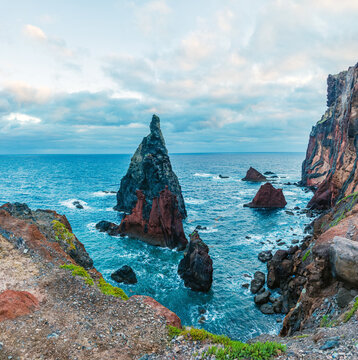 Sharp volcanic sea stacks rising dramatically from the blue ocean waters near the rocky coast of Ponta de Sao Lourenco, Madeira, Portugal.