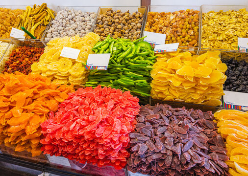 A colorful commercial display of various bright candied dried fruits and sweets at a local market stall, Funchal, Madeira, Portugal.