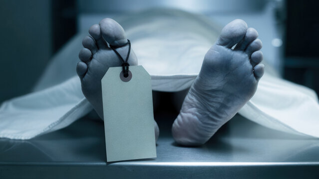 Deceased feet with identification tag on sterile morgue table