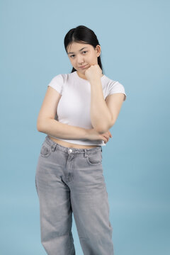 Pregnant woman standing sideways looking upwards touching her neck