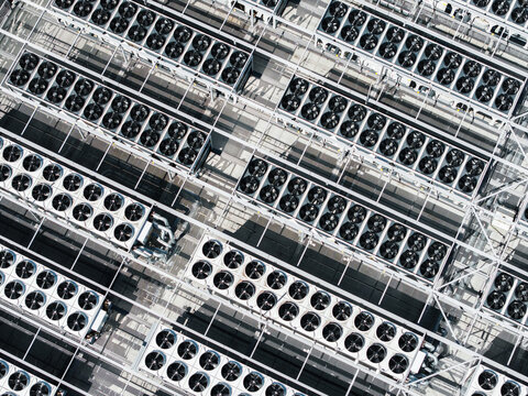 Aerial view of industrial cooling fans arranged in rows on a rooftop in Riga, Latvia.