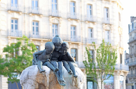 DIJON, FRANCE &ndash; APRIL 29, 2026: Bronze sculpture of three young children on the Fountain Jeunesse created by the artist Max Blondat in 1904. Selective focus