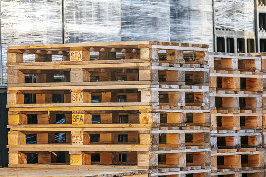 Valmiermuiza, Latvia - July 03, 2026: Stacked wooden pallets with visible markings in a warehouse setting, showcasing industrial storage and logistics materials