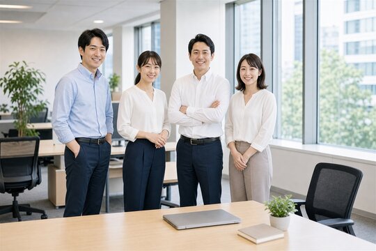 窓際の会議室で並ぶクールビズの四人