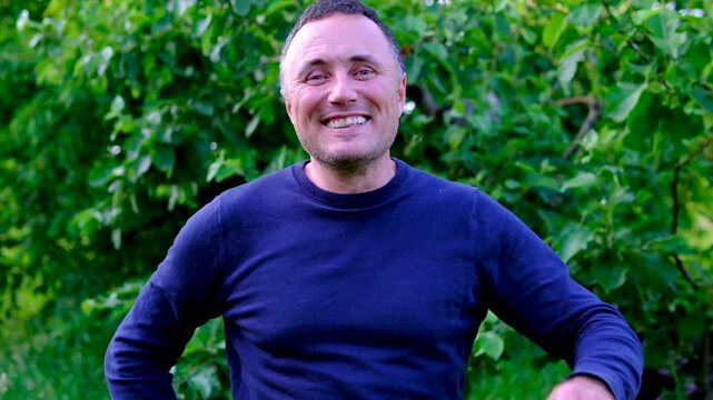 A burst of genuine laughter fills the scene as a cheerful gardener claps his hands and turns away with delight. Natural reactions and positive emotions create an authentic atmosphere of happiness.