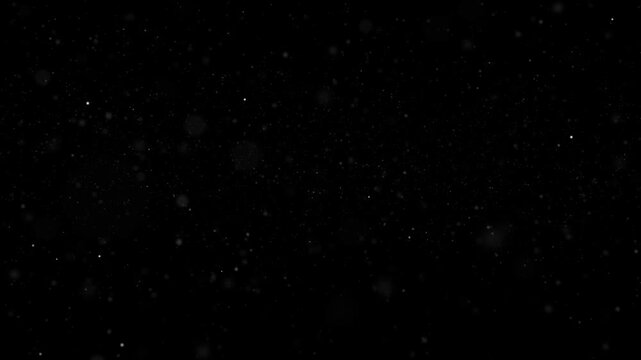Particles Flowing Forward in Space 4K Loop features a flight through space with white particles of varying shapes and sizes coming toward the viewer in a loop. 
