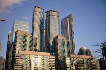 Twin cylindrical residential towers rise above bare tree branches in Toronto, Canada © Moiseii Production